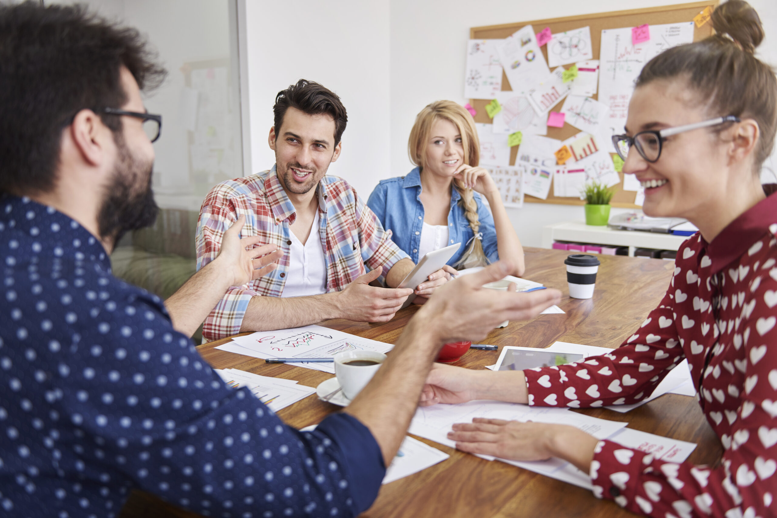 Grupo de personas reunidas debatiendo ideas y trabajando en equipo en dinámica de grupo