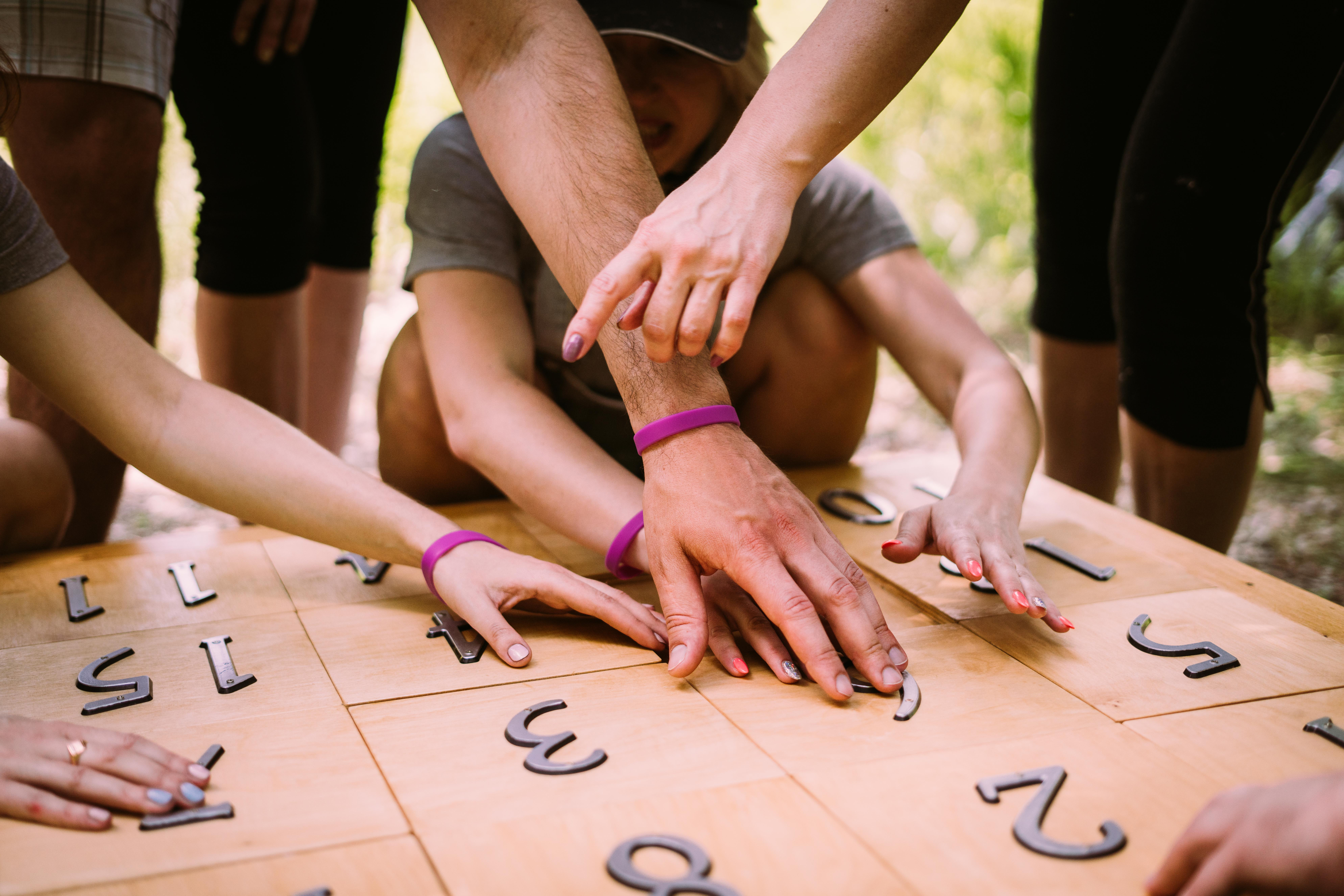 Grupo de jóvenes participando en un juego educativo con números durante una dinámica de equipo.