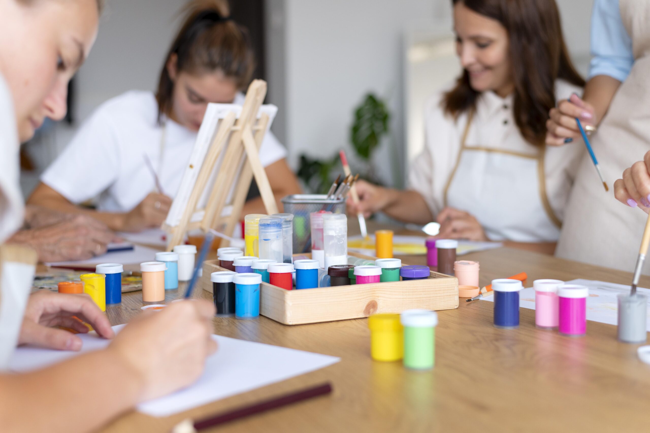 Niños pintando y realizando actividades artísticas en un taller creativo dentro de un centro educativo.