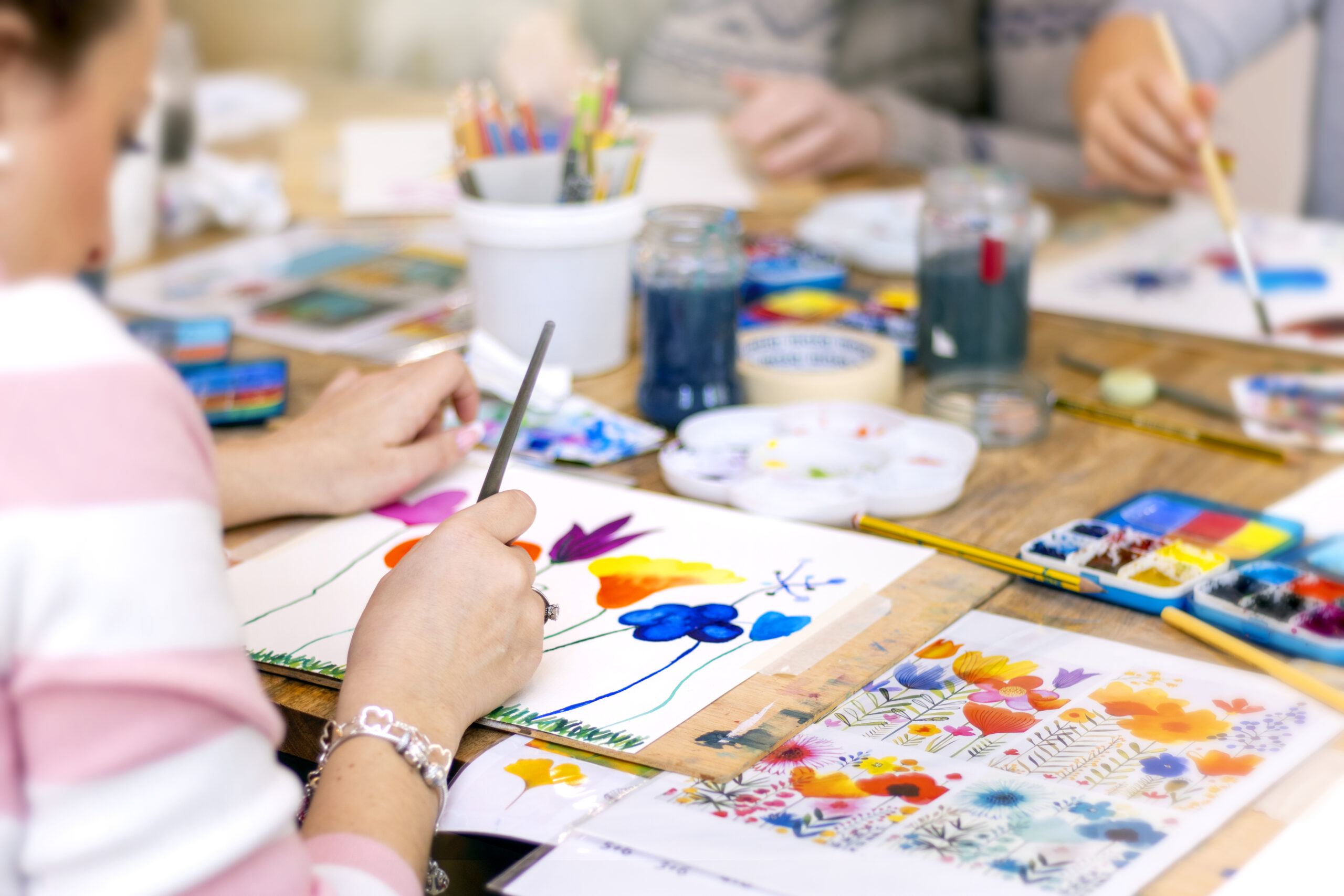 Alumno pintando un dibujo con acuarelas en un taller creativo dentro de un centro educativo.