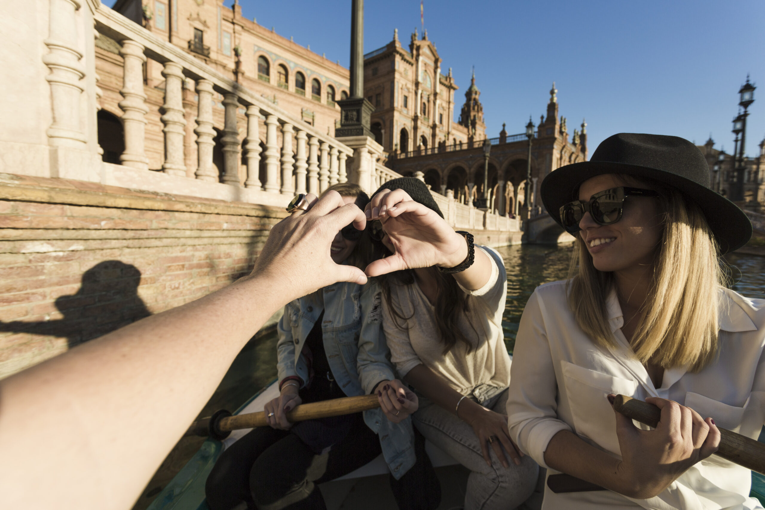 Personas haciendo un gesto de corazón con las manos mientras disfrutan de un paseo en un entorno cultural