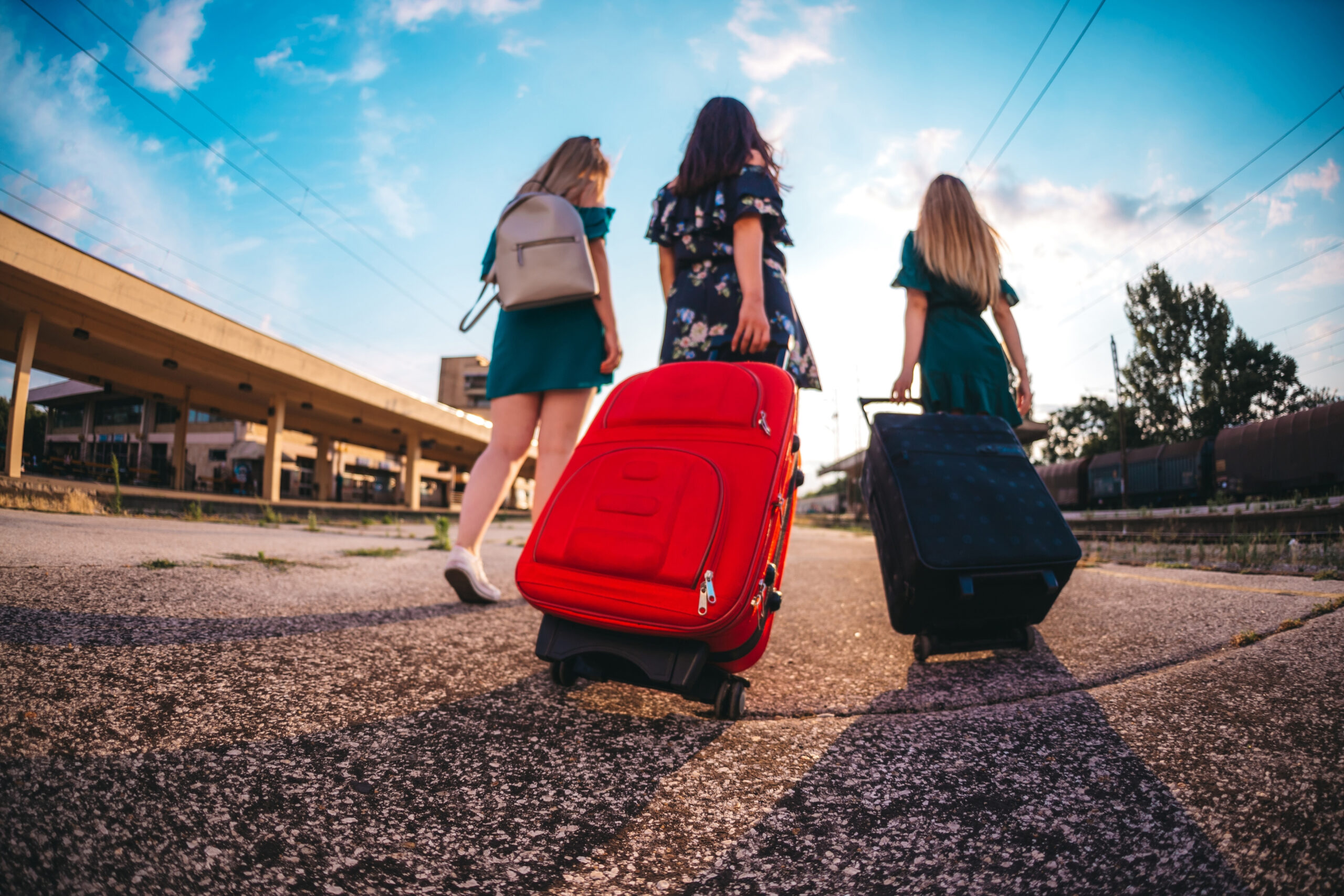Grupo de estudiantes con maletas iniciando un viaje de fin de curso en una estación.